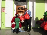 Governor de Jongh helps Santa hand gifts to the children