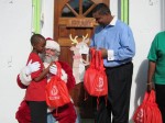 Governor de Jongh helps Santa hand gifts to the children
