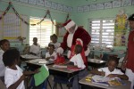 Kids get a break from their regular school day when Santa Claus stops by with gifts for all. Cecile de Jongh, First Lady of the U.S. Virgin Islands looks on.