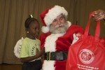 Receiving her gift bag with the hardcover picture book "Efa and the Mosquito" inside, from Santa himself. Pearl B. Larsen Elementary School, St Croix.